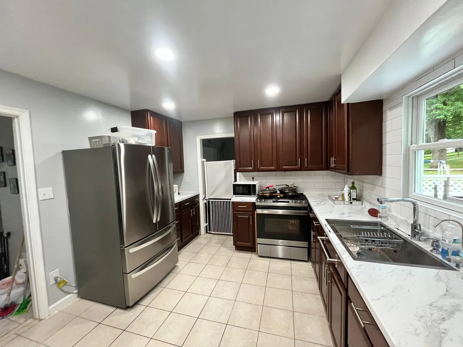 Cocina remodelada con isla central y acabados en cuarzo blanco