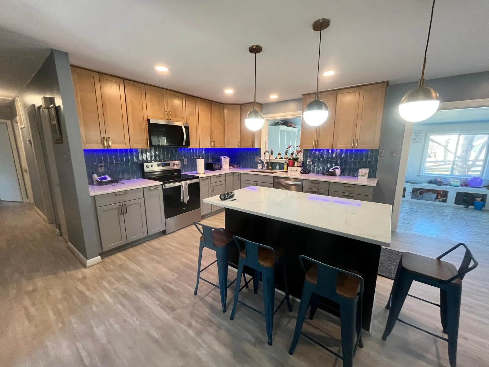 Cocina remodelada con isla central, iluminación empotrada y pisos nuevos